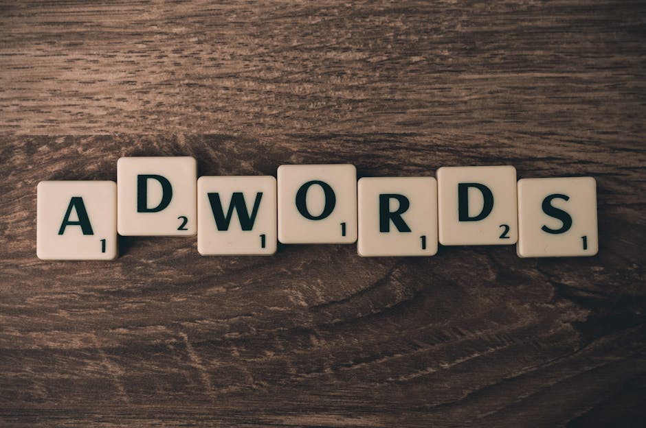 Scrabble tiles spelling 'AdWords' on a wooden surface